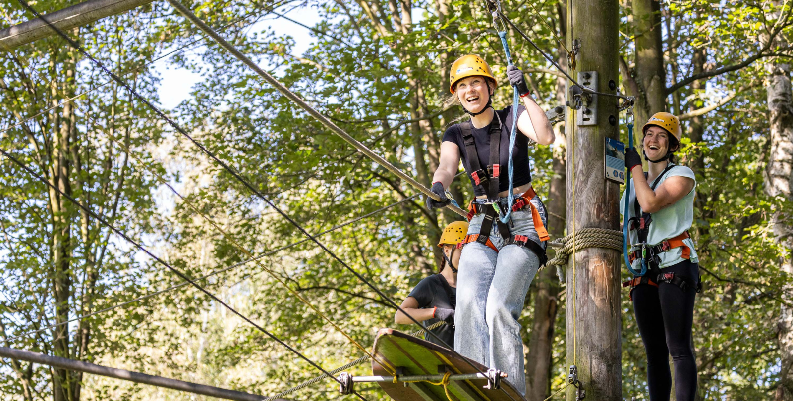 Drei Jugendliche versuchen ein Balancierelement zu meistern