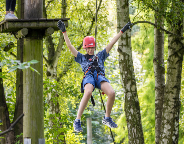 Junge gleitet die Schwebebahn entlang