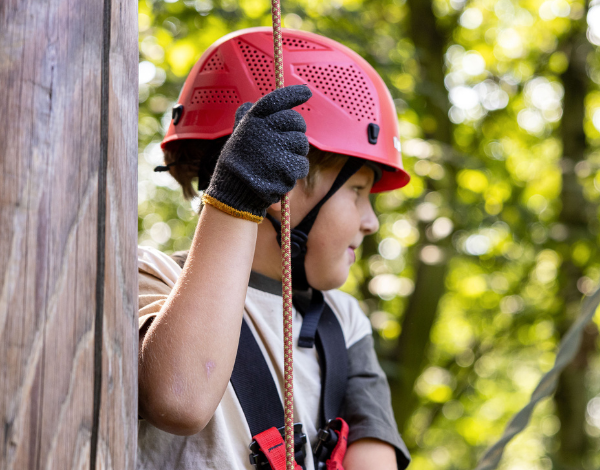 Junge im Halbportrt hlt sich an einem Seil fest