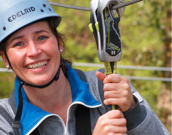 Portrtfoto junge Frau in Kletterausrstung schaut lchelnd in die Kamera